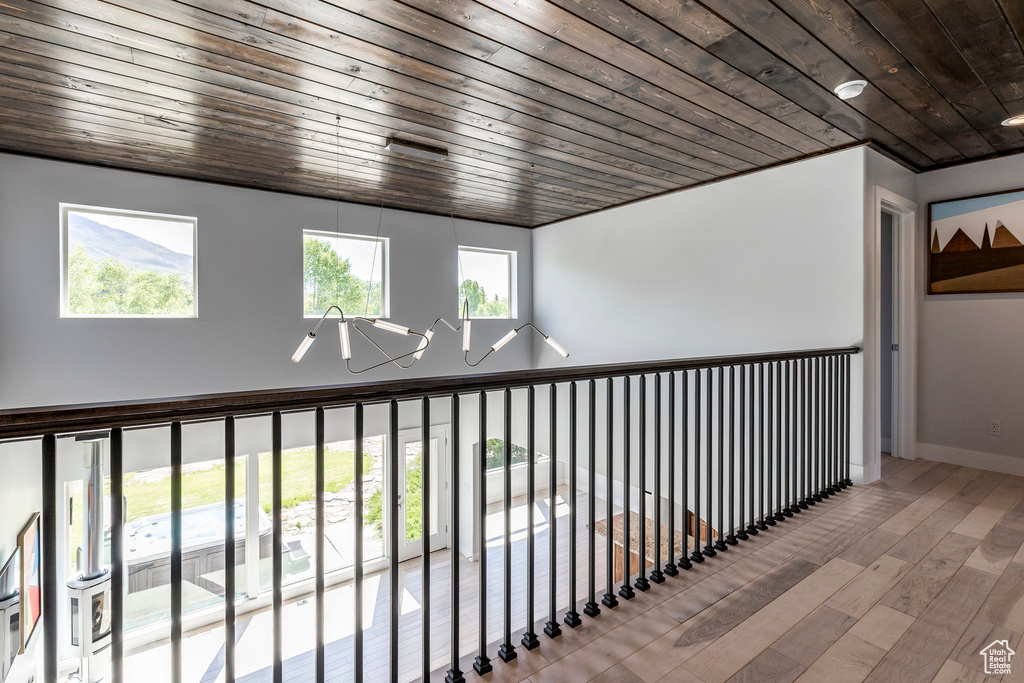 Corridor featuring wood ceiling, wood finished floors, and baseboards