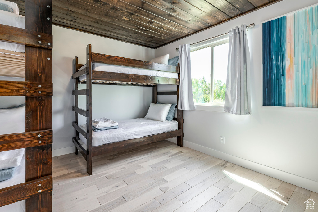 Bedroom featuring baseboards, wood finished floors, and wooden ceiling
