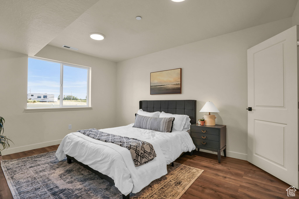 Bedroom with baseboards and dark wood-style flooring