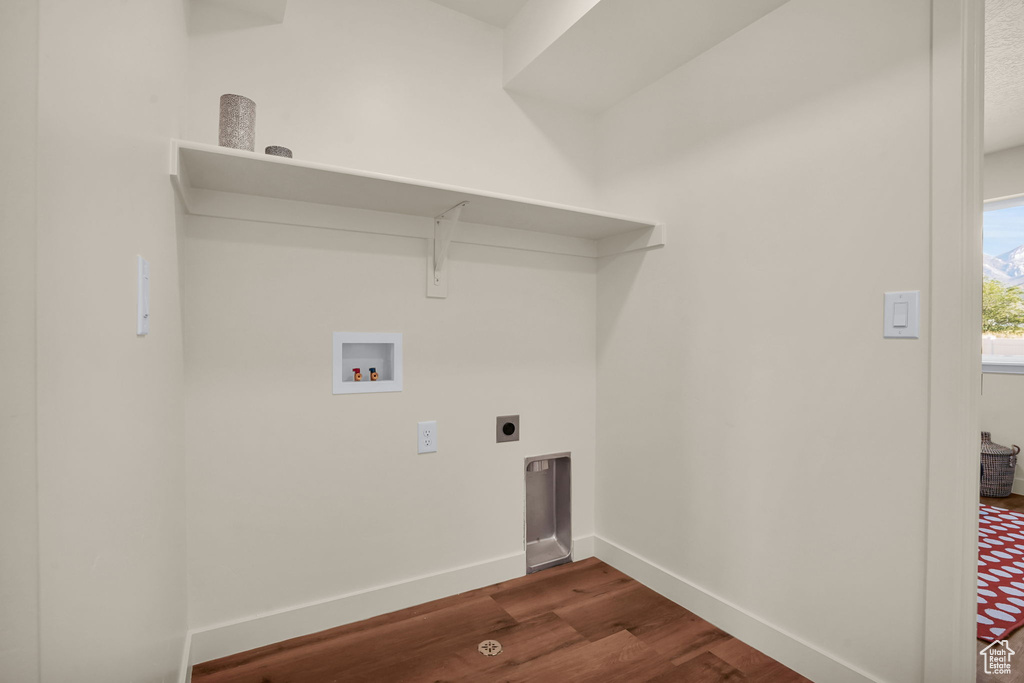 Laundry area featuring hookup for a washing machine, electric dryer hookup, dark wood finished floors, and baseboards