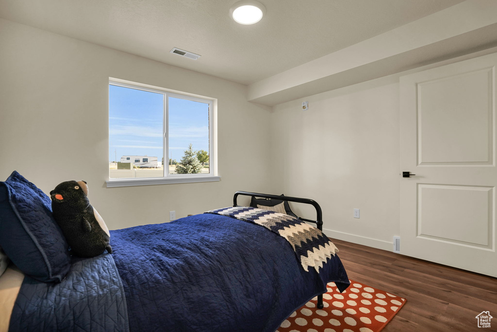 Bedroom with wood finished floors and baseboards