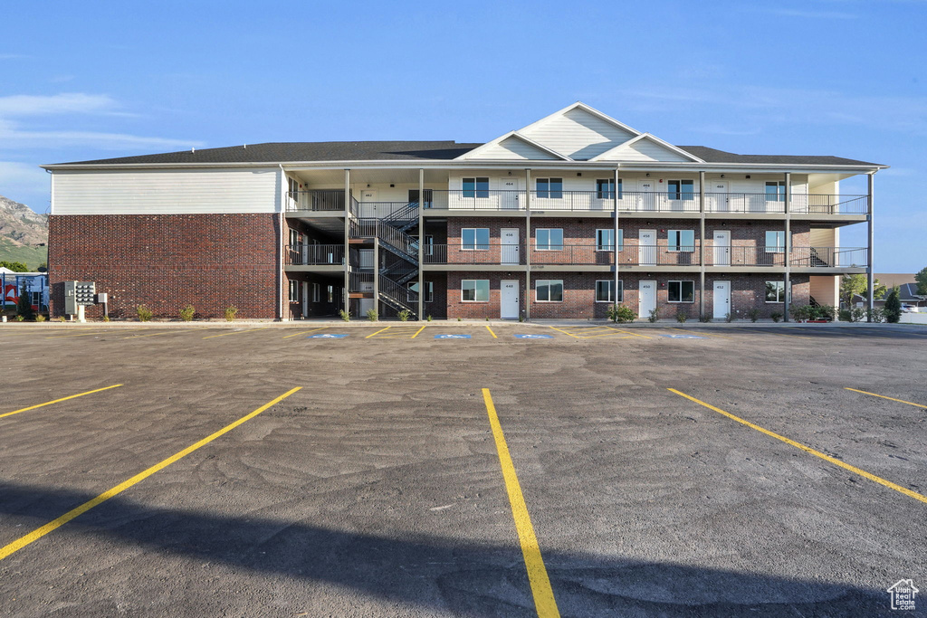 View of apartment building / complex featuring uncovered parking