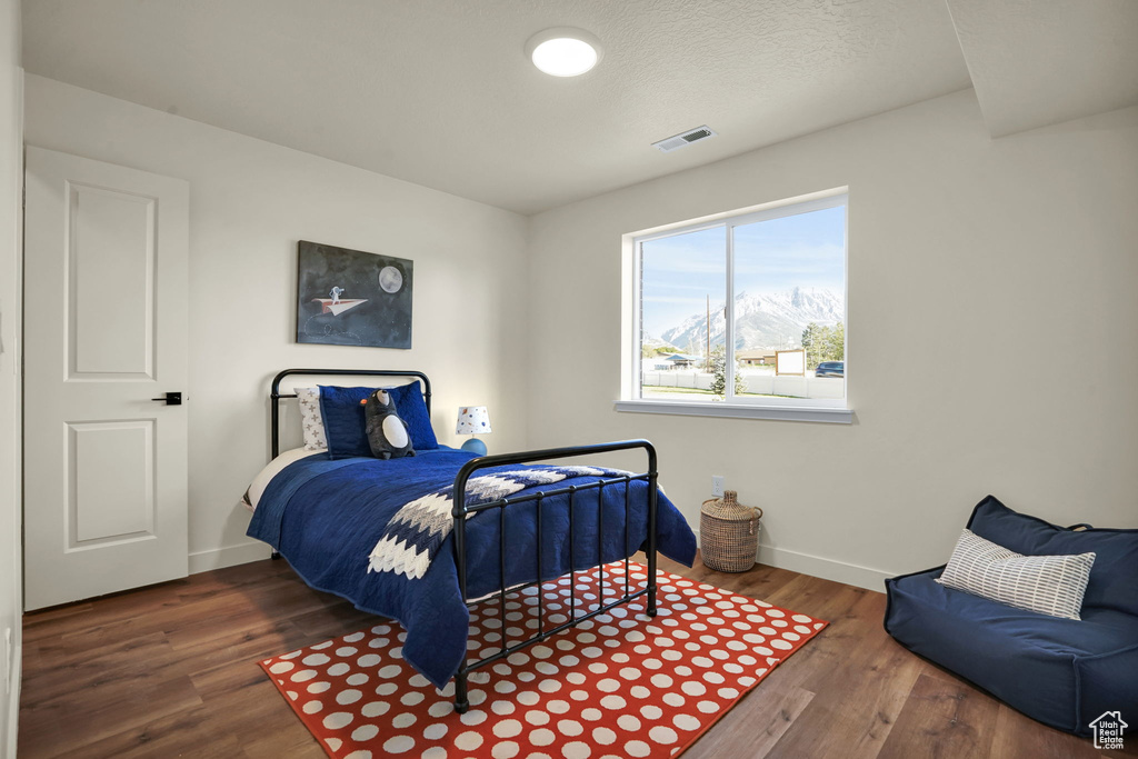 Bedroom with wood finished floors and baseboards