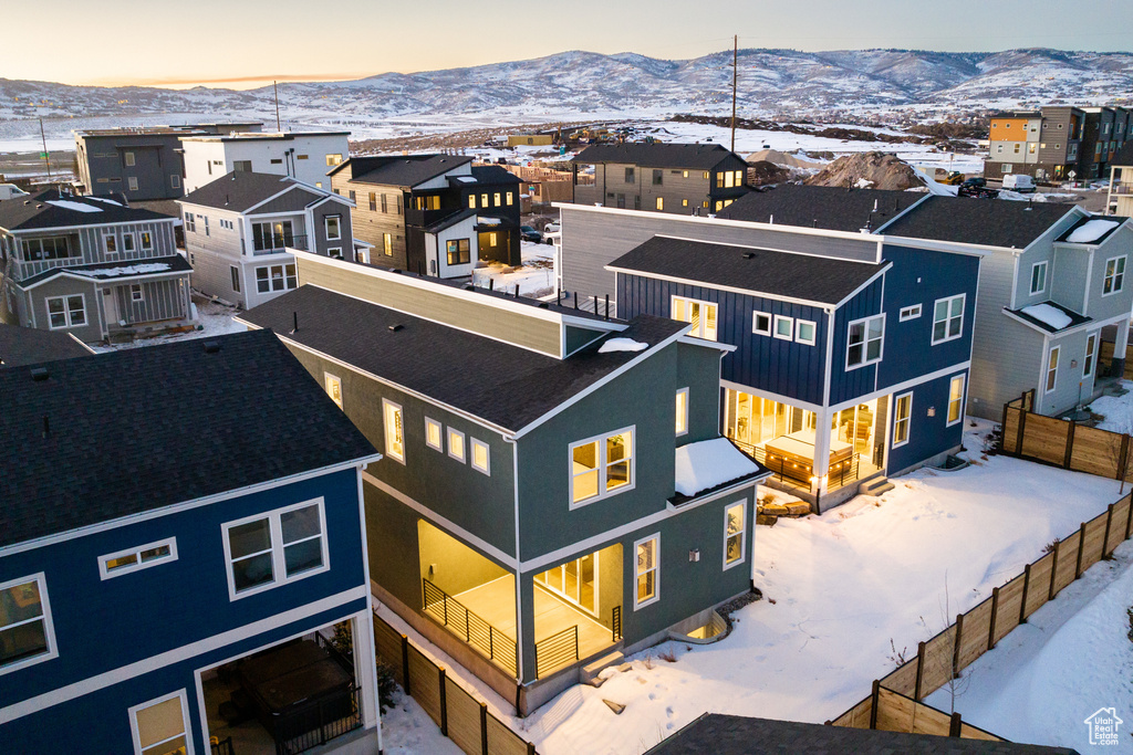 Snowy aerial view featuring a mountain view and a residential view