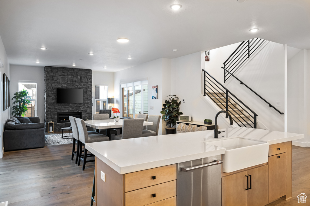 Kitchen featuring a sink, dishwasher, healthy amount of natural light, light brown cabinetry, and recessed lighting