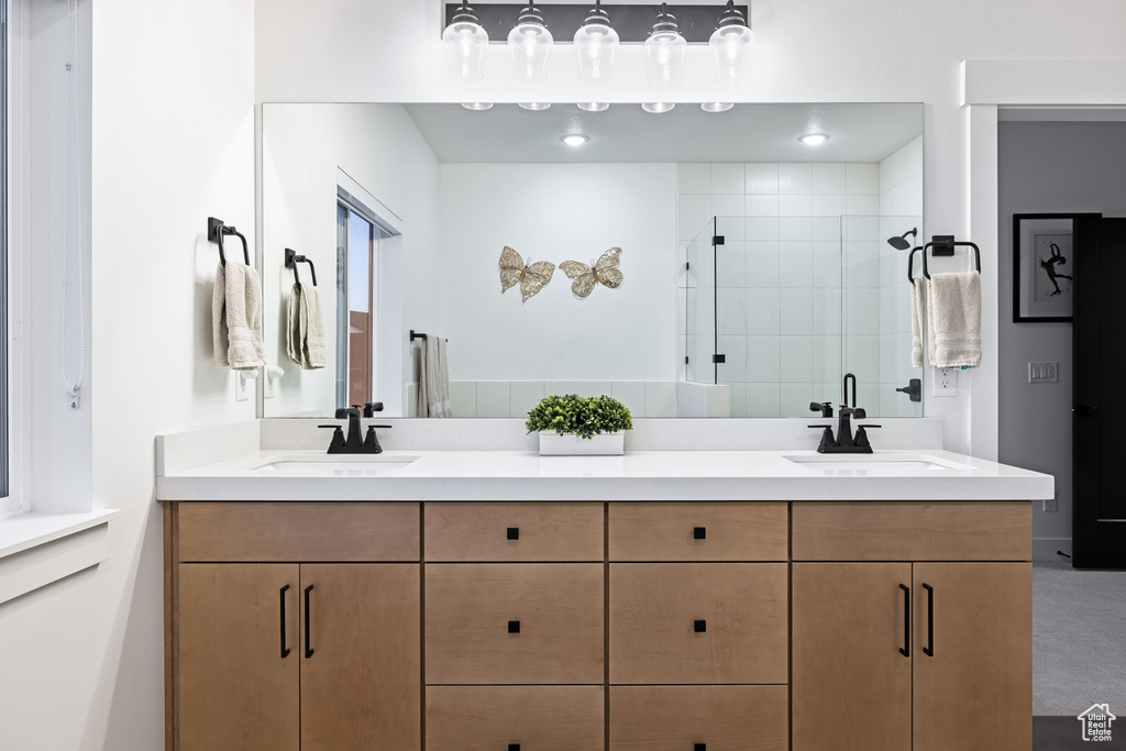 Bathroom featuring a shower stall and double vanity