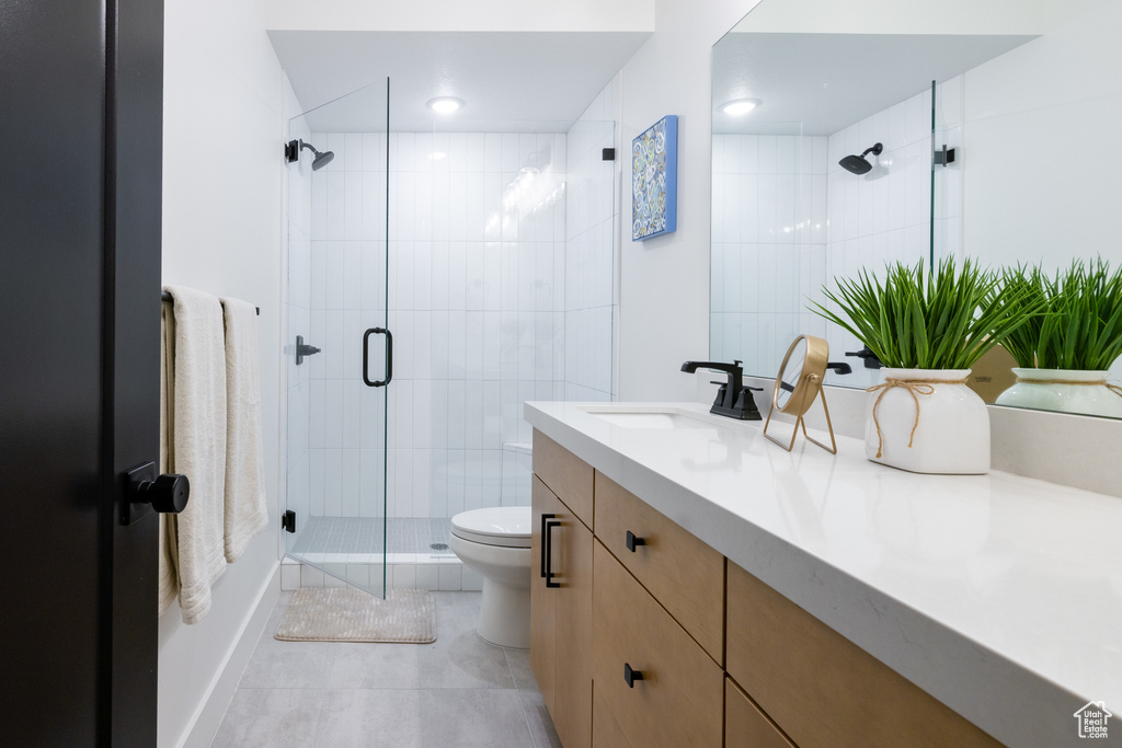 Bathroom featuring vanity, a shower stall, toilet, tile patterned flooring, and recessed lighting