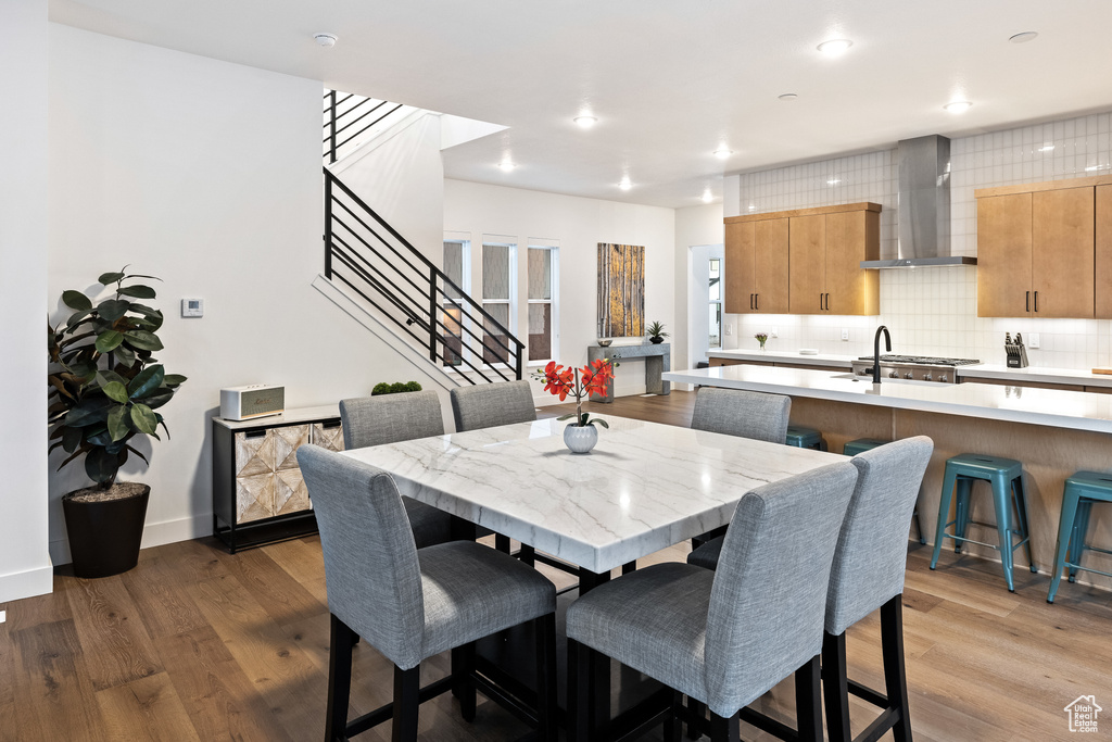 Dining space featuring wood finished floors, stairs, recessed lighting, and baseboards