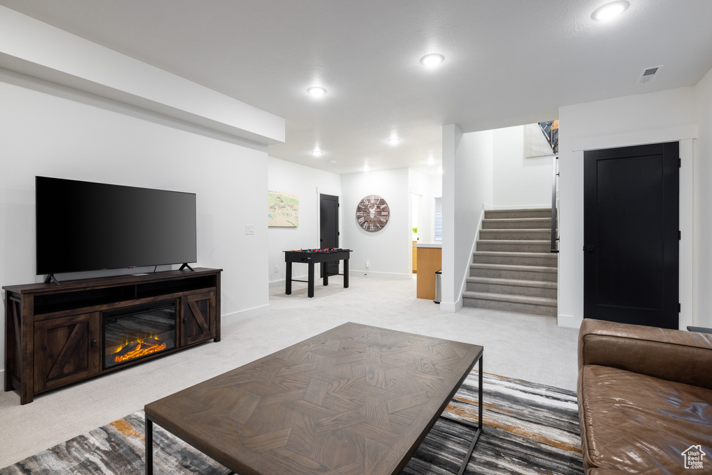 Living area featuring stairway, light carpet, recessed lighting, and baseboards