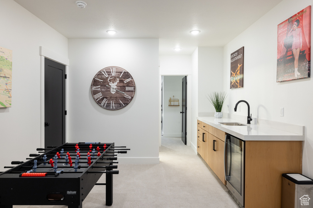 Playroom with a sink, beverage cooler, light carpet, baseboards, and recessed lighting