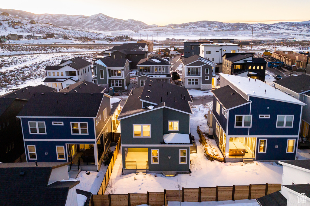 Snowy aerial view featuring a residential view and a mountain view