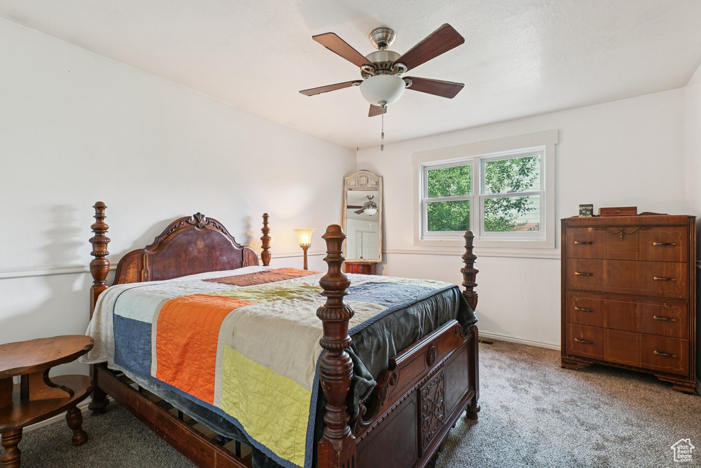 Carpeted bedroom featuring a ceiling fan