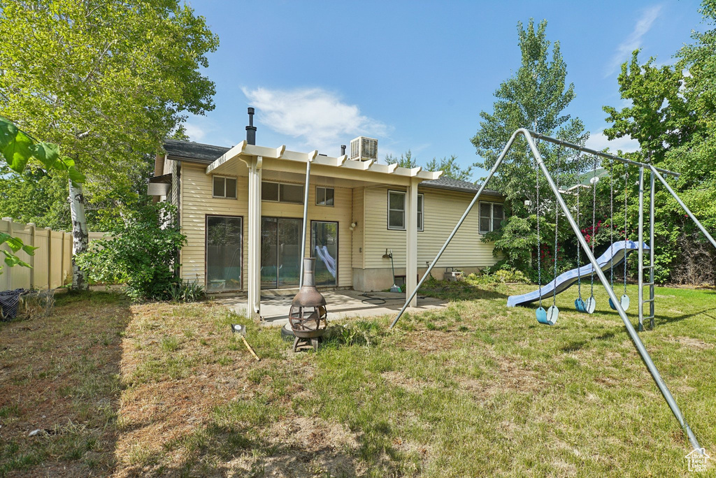 Rear view of house featuring a patio, a fire pit, and cooling unit