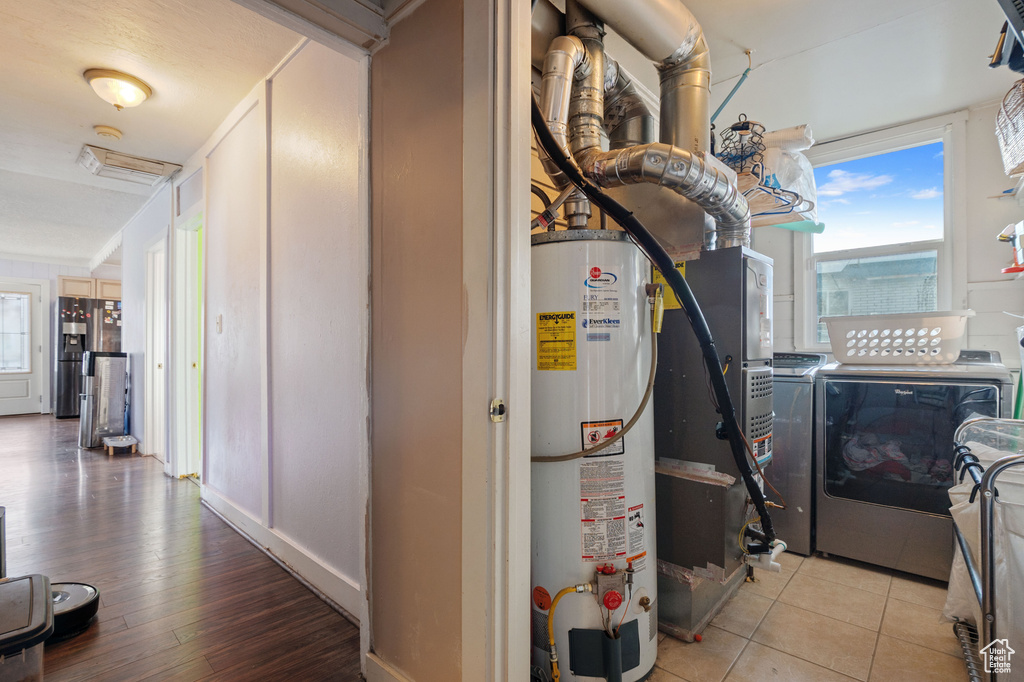 Utility room with water heater, independent washer and dryer, and heating unit