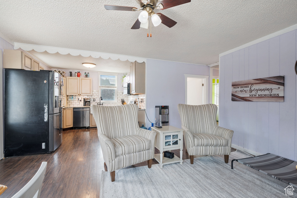 Sitting room featuring a ceiling fan, dark wood-type flooring, and a textured ceiling