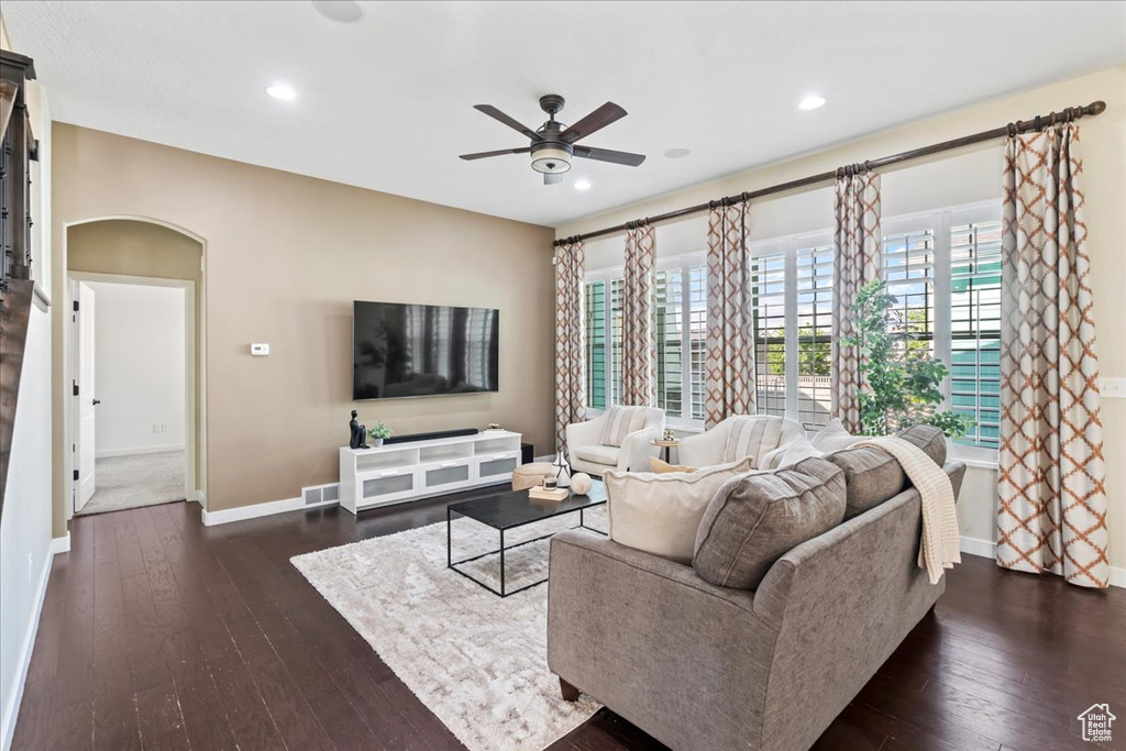 Living area with ceiling fan, baseboards, dark wood-type flooring, recessed lighting, and arched walkways