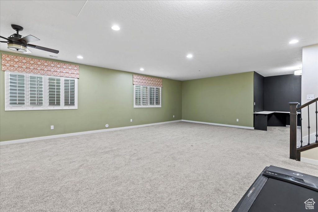 Unfurnished living room featuring carpet flooring, a ceiling fan, recessed lighting, and baseboards