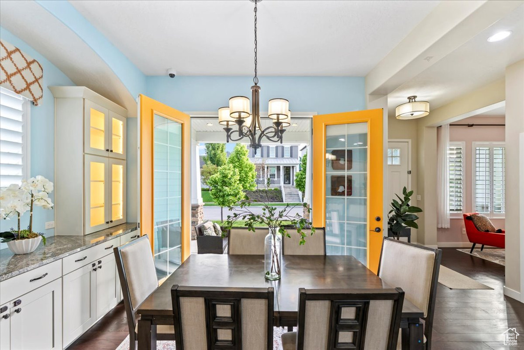Dining room with a chandelier, dark wood-style flooring, baseboards, and recessed lighting