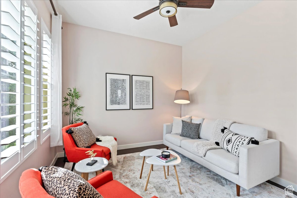 Living area with a ceiling fan, baseboards, and wood finished floors