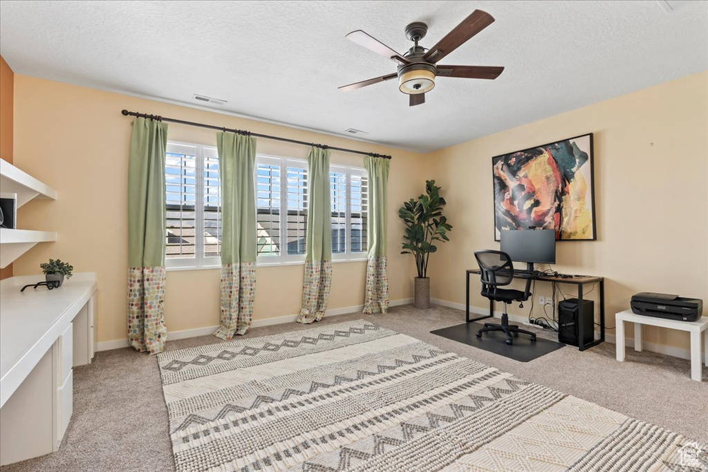 Home office with carpet, plenty of natural light, ceiling fan, a textured ceiling, and baseboards