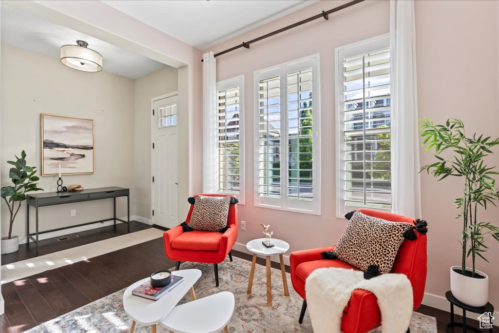 Sitting room with healthy amount of natural light, wood finished floors, and baseboards