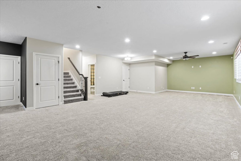 Below grade area featuring carpet floors, a ceiling fan, stairs, recessed lighting, and baseboards