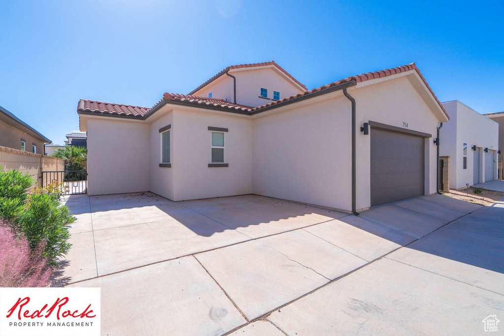 Mediterranean / spanish house featuring stucco siding, an attached garage, concrete driveway, and a tile roof