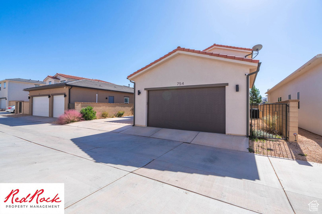 View of front of home with stucco siding, a tiled roof, and concrete driveway