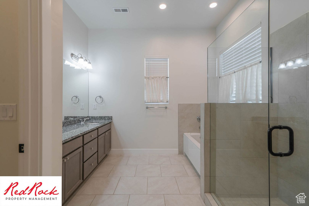 Full bathroom with vanity, tile patterned flooring, a bath, baseboards, and a shower stall