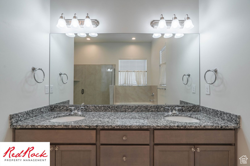 Full bathroom featuring a shower stall and double vanity