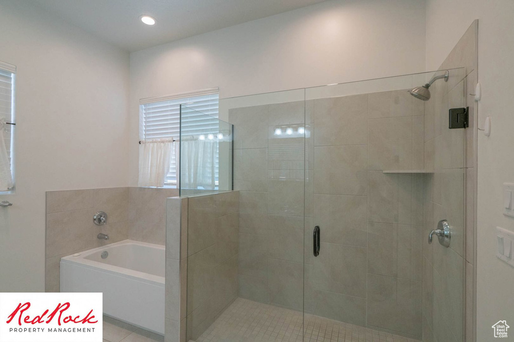 Bathroom featuring a stall shower and a bath
