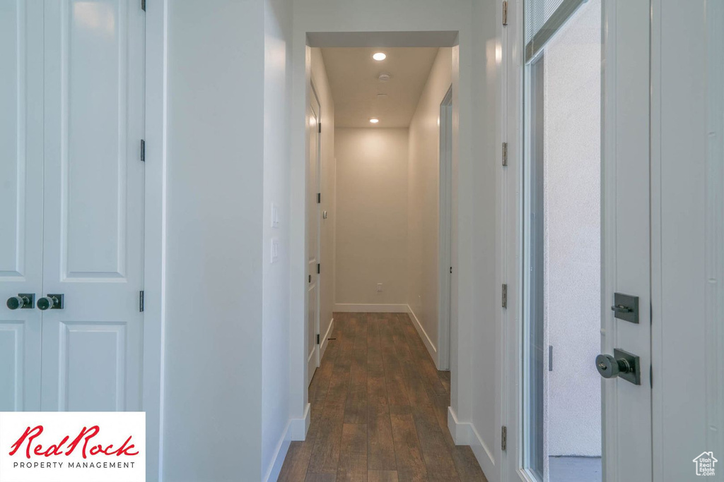 Hall with dark wood-style flooring, recessed lighting, and baseboards