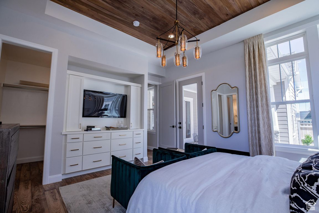 Bedroom with wooden ceiling, multiple windows, dark wood finished floors, a chandelier, and baseboards