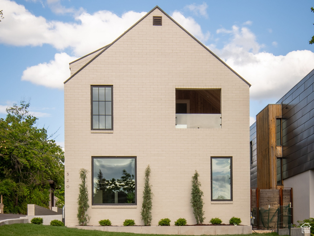 View of side of property featuring brick siding and a lawn