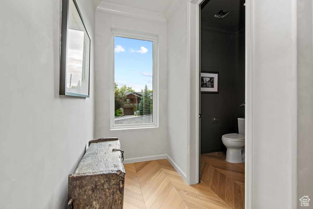 Bathroom with toilet and ornamental molding