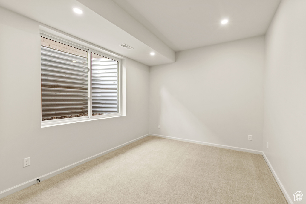 Spare room featuring recessed lighting, light colored carpet, and baseboards