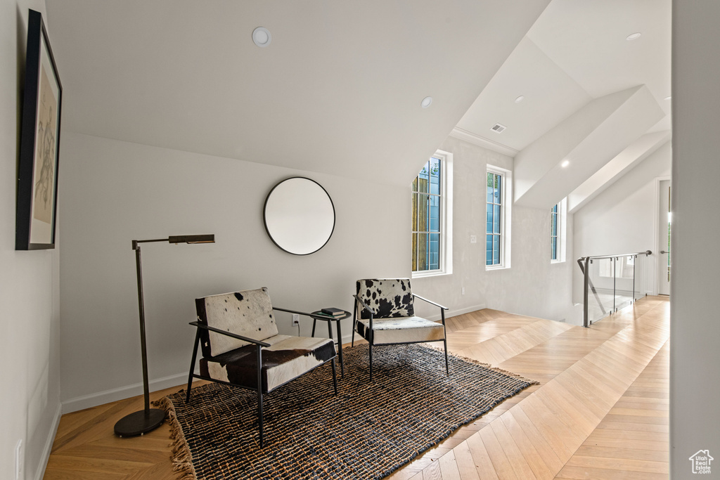 Sitting room with an upstairs landing, lofted ceiling, and baseboards