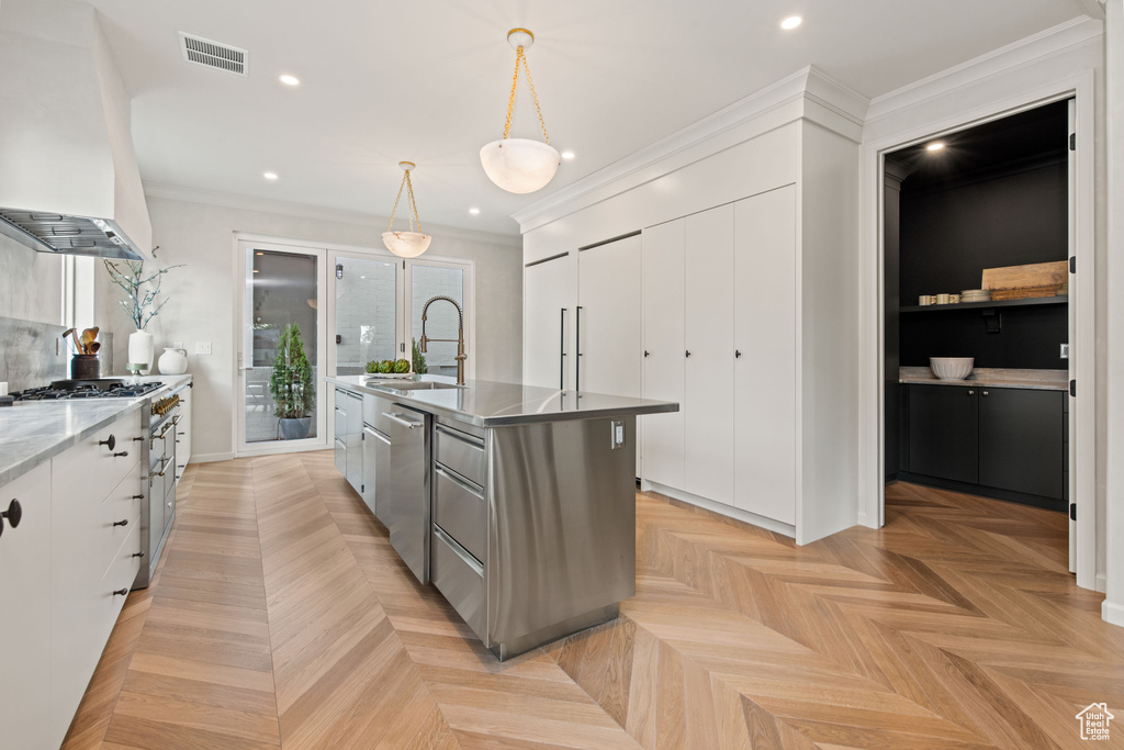 Kitchen with a sink, wall chimney exhaust hood, dishwasher, white cabinetry, and a kitchen island with sink