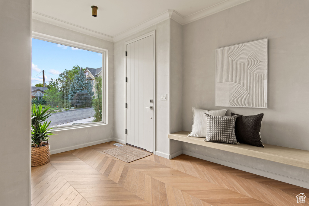 Foyer entrance featuring crown molding and baseboards