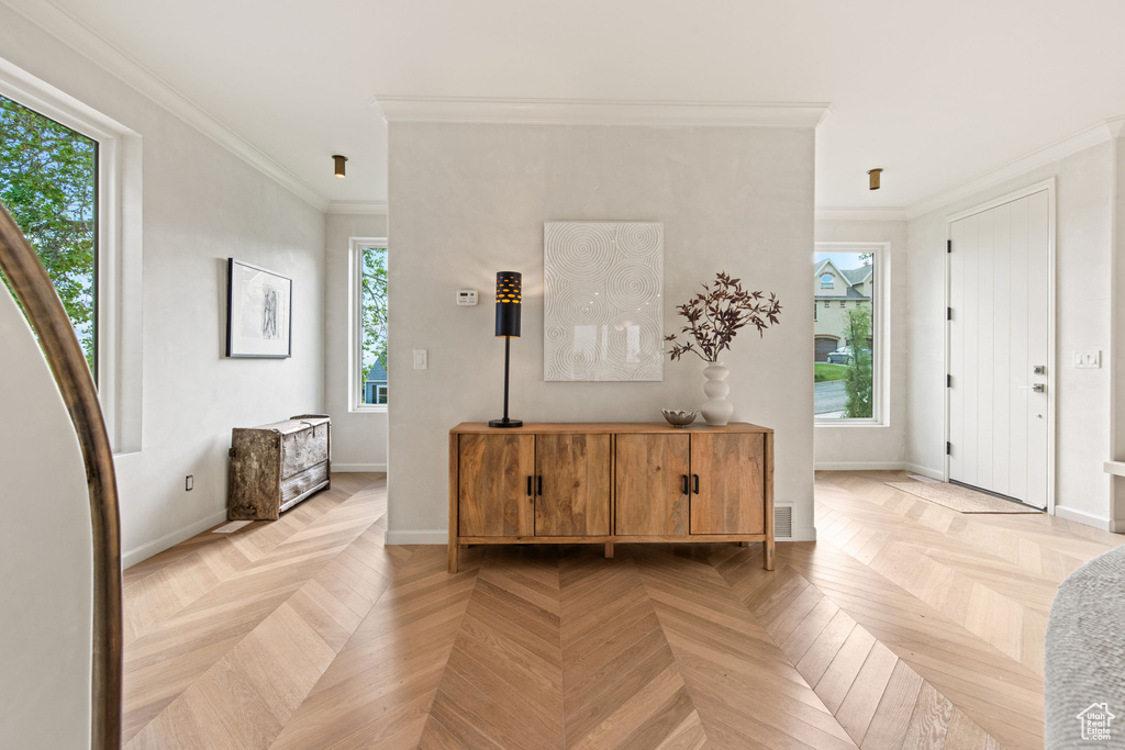 Entrance foyer with crown molding and baseboards