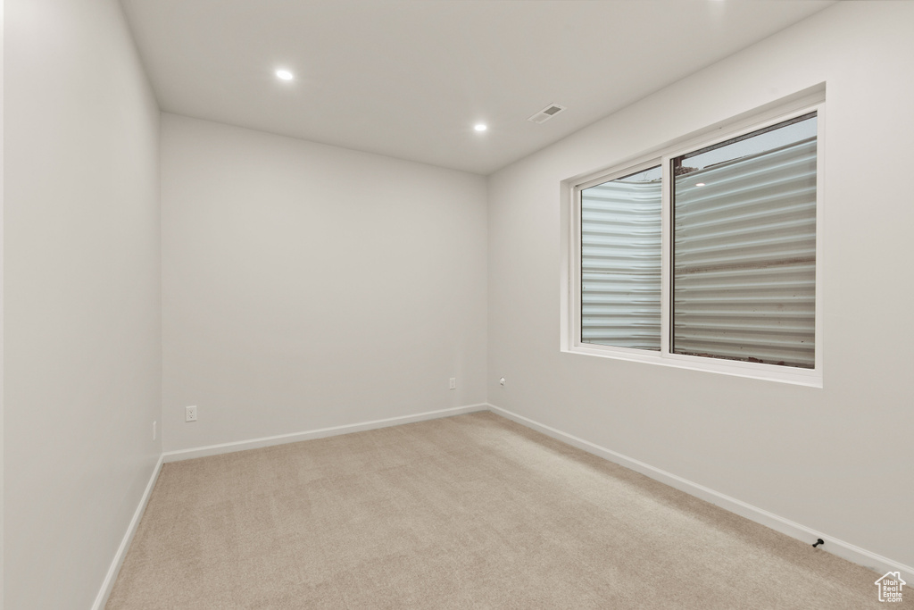 Empty room with light carpet, baseboards, and recessed lighting