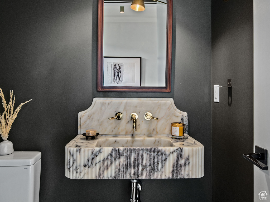 Half bath featuring toilet and a sink