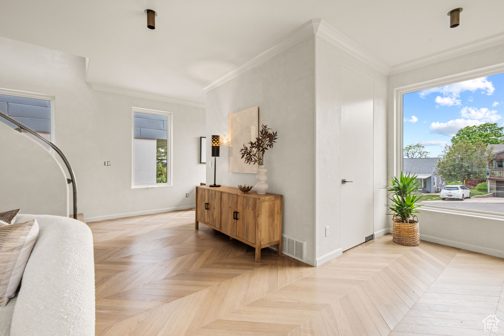 Foyer featuring crown molding and baseboards