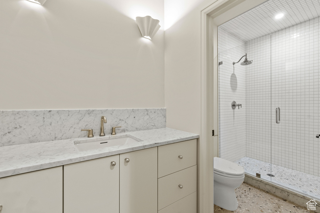 Full bathroom with toilet, a stall shower, and vanity