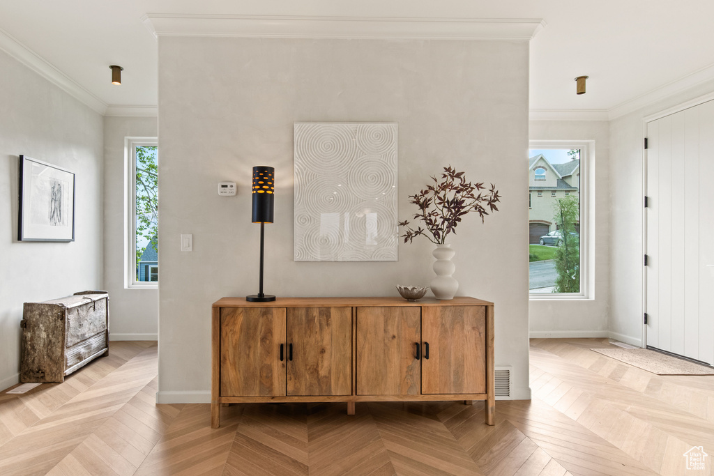Entrance foyer featuring crown molding and baseboards