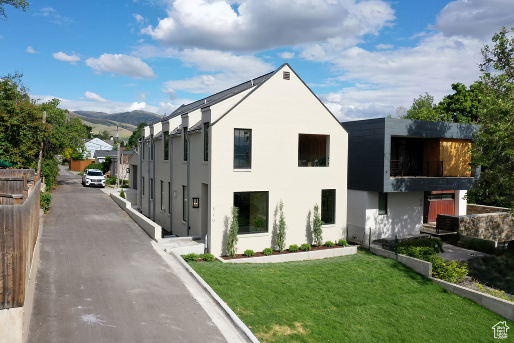 View of home\\\\\\\'s exterior with a mountain view, a lawn, and stucco siding