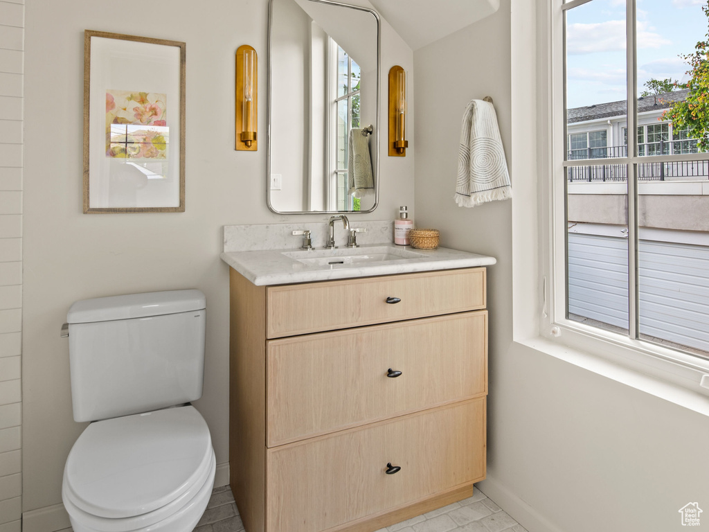 Bathroom featuring lofted ceiling, baseboards, toilet, vanity, and crown molding