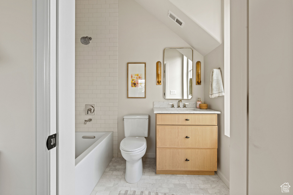 Full bathroom with toilet, vanity, bathtub / shower combination, and vaulted ceiling