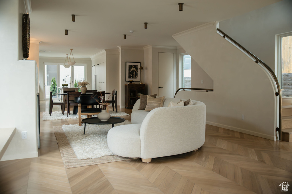 Living area featuring baseboards and crown molding
