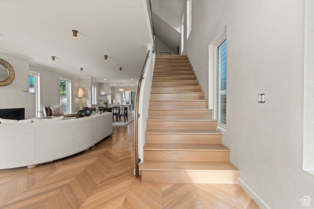 Staircase with baseboards, a fireplace, and crown molding